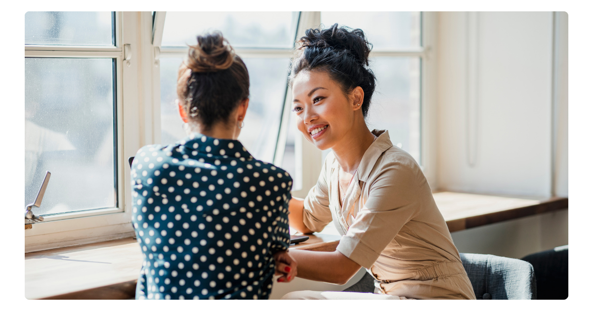 photo of two individuals talking to one another 